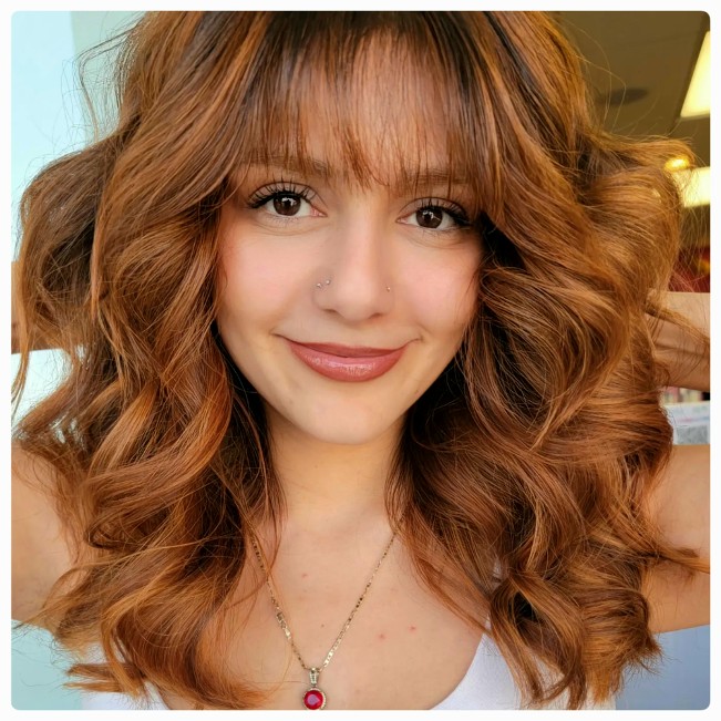A woman with flowing brown hair showcasing a refined and sophisticated look.